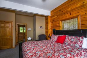um quarto com uma cama vermelha e uma parede de madeira em Cozy Bear Chalet em McHenry