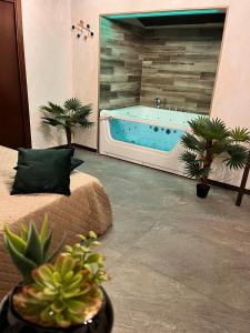 baño con bañera, cama y macetas en Nid’Amour suite&spa en Palermo