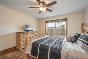 a bedroom with a bed with a ceiling fan and a window at Happy Ours in McHenry