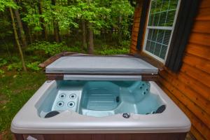 a hot tub sitting outside of a house at Knotty Pines in Oakland +59 photos