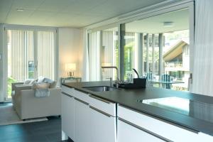 a kitchen with a sink and a living room at Schlossblick in Spiez