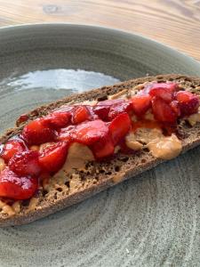 a piece of bread with strawberries on it on a plate at Boutique Hotel Sant Roc & Spa in Mahón