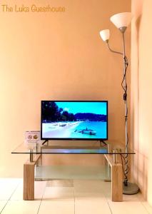 a living room with a television on a glass table at The Luka Guesthouse and Restaurant in Patong Beach
