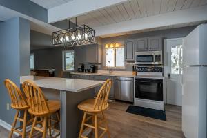a kitchen with a counter and stools in it at Lake Life HQ in McHenry