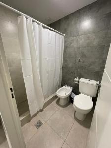 y baño con aseo, ducha y lavamanos. en Hermoso departamento en Mendoza en Godoy Cruz