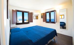 - un lit bleu dans une chambre avec fenêtres dans l'établissement Casa Due Lune, à Stromboli