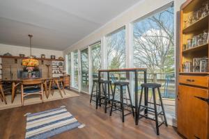 a kitchen with a table and stools in a room with windows at Just Around the Dilly in Swanton +83 photos
