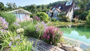 a house with a pond and flowers in front of it at Apartment Seerose in Remseck am Neckar