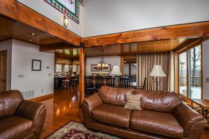 a living room with a leather couch and a dining room at Hawk Mountain in McHenry