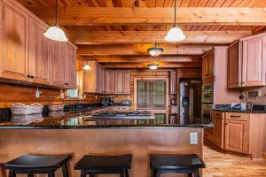 a large kitchen with wooden cabinets and black counter stools at Altitude Adjustment in McHenry