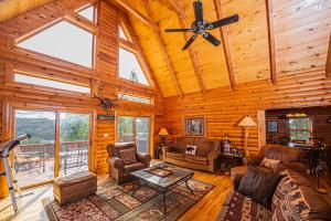 a living room with a ceiling fan and furniture in a cabin at Altitude Adjustment in McHenry