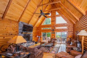 a living room with a fireplace in a log cabin at Altitude Adjustment in McHenry
