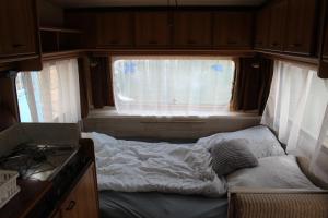 a small bed in the middle of a room with a window at Kemping pod figą in Granichar