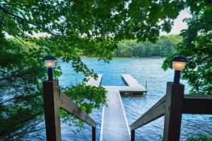 a dock on a lake with two lights on it at Lakey McLakeHouse in Swanton