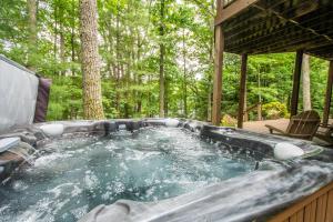 a jacuzzi tub in the backyard of a cabin at Lakey McLakeHouse in Swanton
