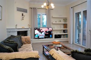 ein Wohnzimmer mit einem Sofa und einem TV in der Unterkunft La Bella Vita - Luxury Holiday House close to Corfu Town in Potamós