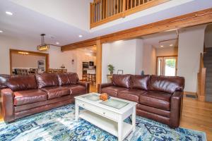 a living room with two brown leather couches and a table at Lakey McLakeHouse in Swanton +42 photos