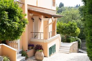a house with a balcony and stairs in a yard at La Bella Vita - Luxury Holiday House close to Corfu Town in Potamós