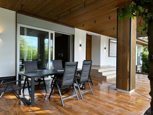 a dining room with a table and chairs on a patio at Villa Wood & Green SPA in Hadžići