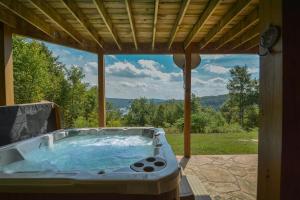 a hot tub on a patio with a view at Highlands Heaven in McHenry