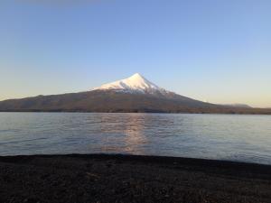 a mountain sitting on the side of a body of water at Habitaciones Punto Medio 1 in Puerto Varas