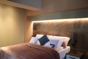 1 dormitorio con 1 cama con cabecero de madera en The Dome Aparthotel, en Satu Mare