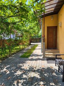 a walkway in front of a house with a bench at Pandora Guest House in Cluj-Napoca