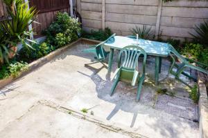 a table and two chairs sitting on a patio at Stylish 4BD House with Private Garden - Stratford in London