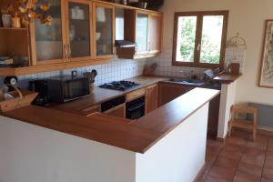 a kitchen with wooden cabinets and a counter top at Orion chalet facing the Meije - 10 persons in La Grave