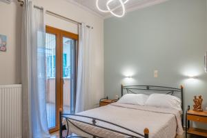 a bedroom with a bed and a window at G.R luxury apartment in Lefkada Town