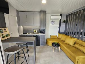 sala de estar con sofá amarillo y cocina en BIG BERRY Kolpa - MerryBerry mobile house, en Metlika