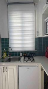 a kitchen with a sink and a window over a stove at Studio El Jamil in Douar el Hafey