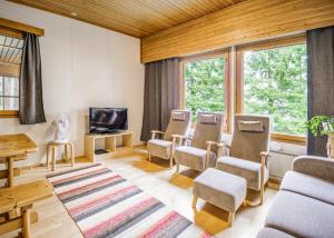 a room with chairs and a table and a tv at Honkiniemi in Ähtäri