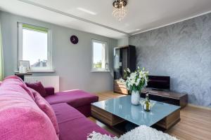 a living room with a purple couch and a table at Elite Apartments Sopot Center in Sopot