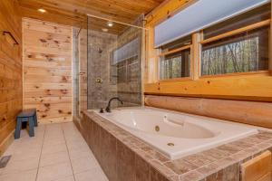 bagno con vasca e finestra di Arya Relaxed Chalet a Swanton