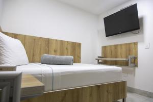 a bedroom with a bed and a flat screen tv at Hotel Park Caribe in Medellín
