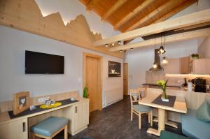 a living room with a table and chairs and a television at Apart Marie-Therese in Umhausen