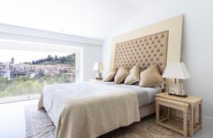 Un dormitorio blanco con una cama grande y una ventana en Villa Argiles, en Bunyola