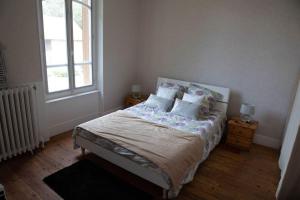 a bedroom with a bed with pillows and a window at Le Refuge - Gîte Familial in Saint-Angel