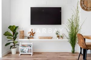 un salon avec une télévision à écran plat sur un mur blanc dans l'établissement Ca Bambú, à Jávea