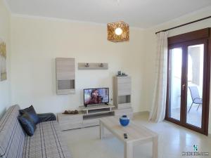 uma sala de estar com um sofá e uma televisão em Village view apartment em Agios Nikolaos