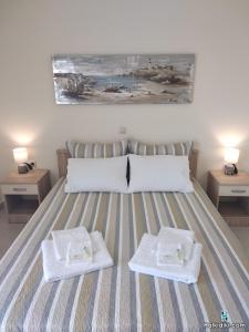 um quarto com uma cama com duas toalhas brancas em Village view apartment em Agios Nikolaos