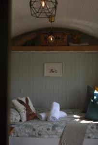 a bedroom with a bed with towels on it at Four Acres Farm Shepherds Huts in Donaghadee