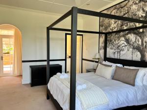 um quarto com uma cama grande com uma moldura preta em Edgehill em Pietermaritzburg