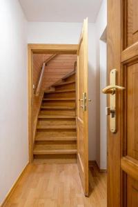 a hallway with a wooden staircase in a house at Apartament Centrum Zakopane in Zakopane