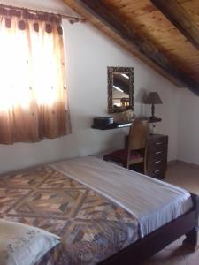 a bedroom with a bed and a desk and a mirror at ΘΕΑΛΟΣ ΒΡΑΧΟΣ in Saterlí