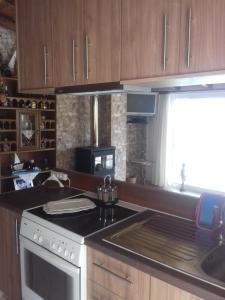 a kitchen with a stove and a sink and a window at ΘΕΑΛΟΣ ΒΡΑΧΟΣ in Saterlí