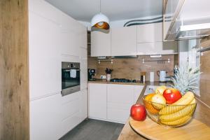 a kitchen with a bowl of fruit on a table at Edonia Garden Home Comfortable & stylish duplex apartment with relaxing private garden in Brodarica