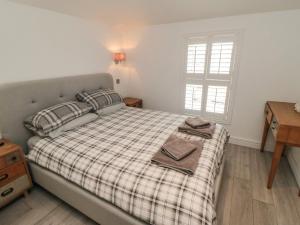 a bedroom with a bed with a plaid blanket at True North in Scarborough