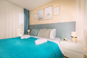 een slaapkamer met een groot bed en een blauwe deken bij Edonia Garden Home Comfortable & stylish duplex apartment with relaxing private garden in Brodarica